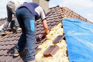 Fairfax, VA emergency tarping contractor working on the top of a roof so that the homeowner does not have to do it himself